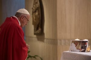 Le pape François priant devant une photographie du père Jacques Hamel.