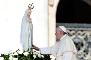 13 mai 2015 : Le pape François touchant la statue de Notre Dame de Fatima lors de l'audience pontificale hebdomadaire sur la place Saint Pierre au Vatican.