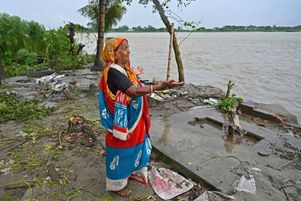 Une femme prie sur le site de son ancienne maison, détruite par l’érosion, sur les côtes de rivière Padma, au Bangladesh, le 13 septembre 2022. 