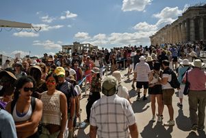 Des touristes font la queue aux Propylées, l'ancienne porte du monument, lors d'une visite de l'Acropole à Athènes, le 14 juin 2023. 