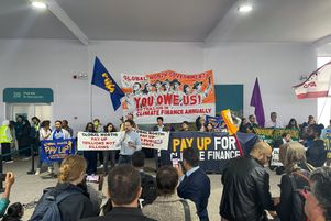 Des militants brandissant des banderoles et des drapeaux pour exiger que les pays riches aident les pays en développement à lutter contre le réchauffement climatique à la COP29, à Bakou.