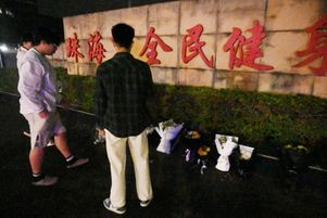 Un groupe d’hommes dépose des fleurs, le 12 novembre 2024, au lendemain de l’attaque à la voiture bélier qui a tué 35 personnes à Zhuhai, dans le sud de la Chine.