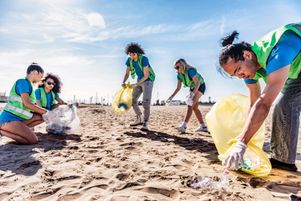 Des écovolontaires collectent des déchets sur une plage. L’encyclique du pape François Laudato si’, publiée il y a dix ans, fait le lien entre religion et écologie.