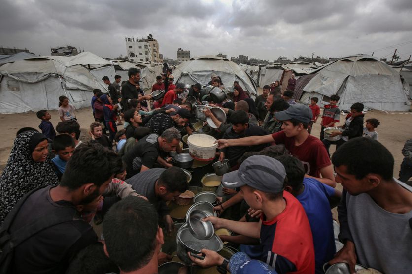 Des Palestiniens reçoivent de la nourriture d’un centre de distribution dans la ville de Gaza, le 13 mai 2025.
